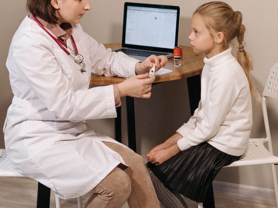 A doctor examining a child with a stethoscope at Laraib Health Clinic